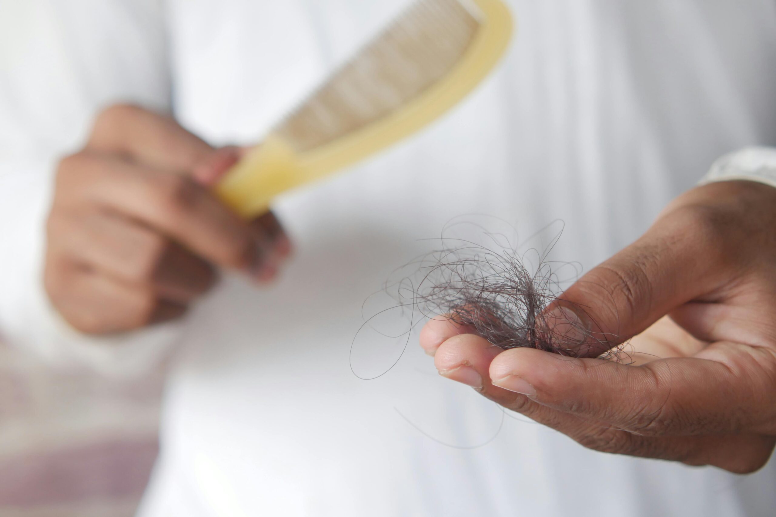 Person holding a comb and hair in their hand