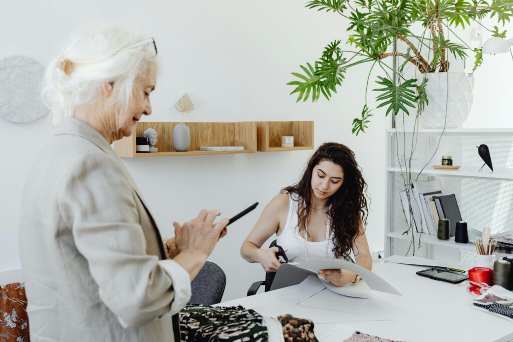 Older woman standing next to table n her phone